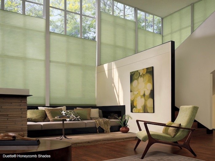 A living room decorated in shades of green. Shown with Duette Honeycomb Shades; available at Dominic's Decorating in Norwalk